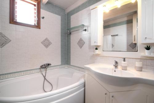 a white bathroom with a tub and a sink at markopoulo-apartmets in Markopoulo