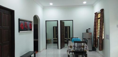 uma sala de estar com mesa, cadeiras e espelhos em Faris's Homestay & Resort em Pasir Puteh