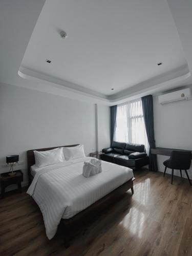 a white bedroom with a bed and a couch at Play Poshtel & Cafe' in Krabi town