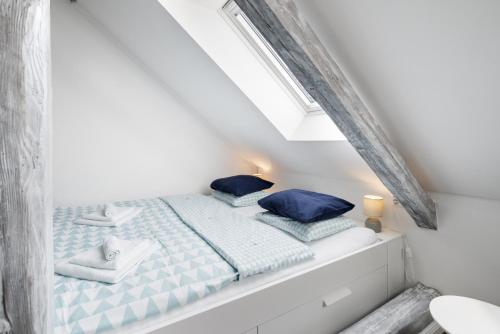 a bedroom with a bed with blue pillows on it at Penzion Belle Donne in Znojmo