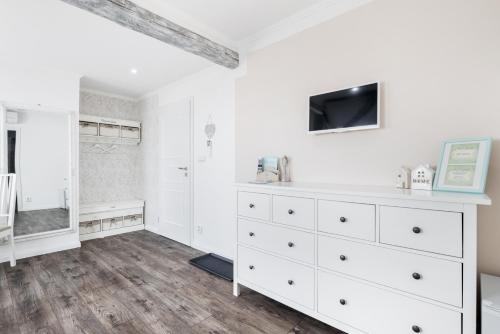 a bedroom with a white dresser with a tv on it at Penzion Belle Donne in Znojmo