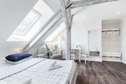 a white bedroom with a bed and a desk at Penzion Belle Donne in Znojmo