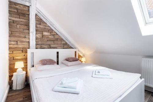 a bedroom with a white bed with two towels on it at Penzion Belle Donne in Znojmo
