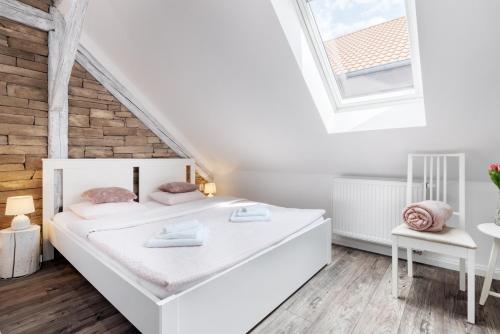 a white bedroom with a bed and a window at Penzion Belle Donne in Znojmo