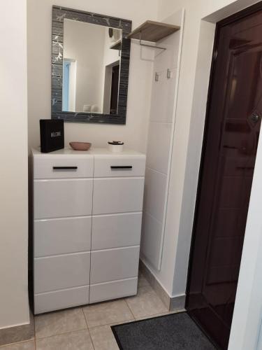 a bathroom with a white dresser and a mirror at Focus Hun in Miercurea-Ciuc