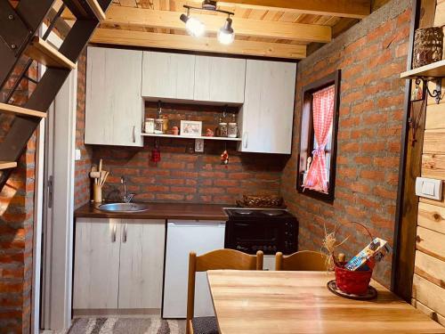 uma cozinha com uma mesa e uma parede de tijolos em Tarska Bajka em Bajina Bašta