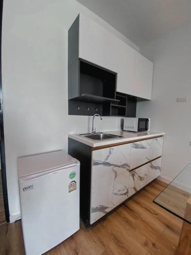 a small kitchen with a sink and a refrigerator at Play Poshtel & Cafe' in Krabi town