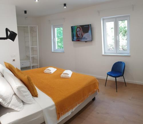 a bedroom with a bed and a blue chair at Luxury TownHouse Baba in Dubrovnik