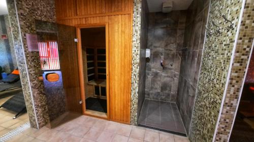 a bathroom with a shower and a glass door at Veronika Hotel in Tisza&uacute;jv&aacute;ros