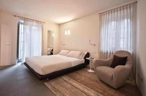 a bedroom with a bed and a chair at Nun Assisi Relais & Spa Museum in Assisi