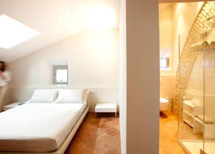 a small bedroom with a bed and a window at Nun Assisi Relais & Spa Museum in Assisi