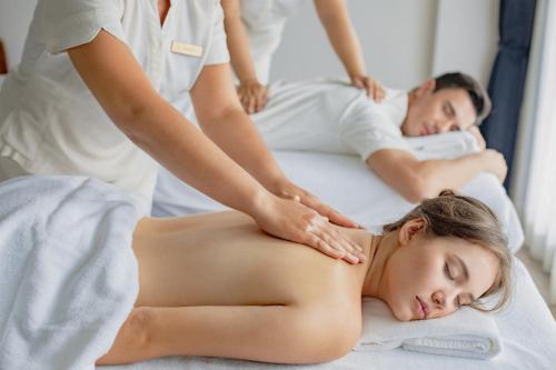 a woman receiving a back massage from a therapist at Avista Grande Phuket Karon - MGallery in Karon Beach