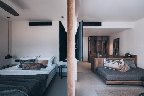 a bedroom with two beds and a bench in it at More Meni Residence & Suites in Tigaki