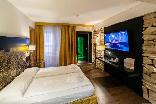 a hotel room with a bed and a flat screen tv at Boutique Exclusive B&B in Trento