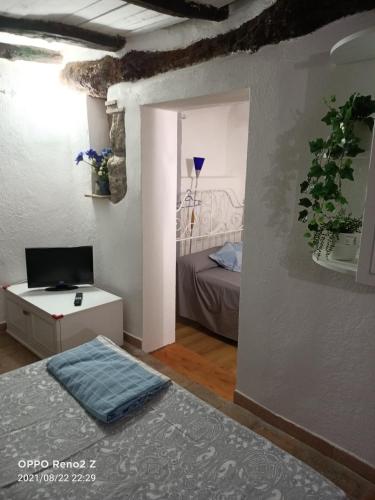a room with a bed and a tv and a table at Casa nella roccia in Bomarzo