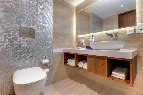 y baño con aseo blanco y lavamanos. en Hotel Aketa Rajpur Road Dehradun, Dehradun, en Dehradun