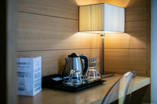 a tea kettle on a table next to a lamp at Boutique Exclusive B&B in Trento