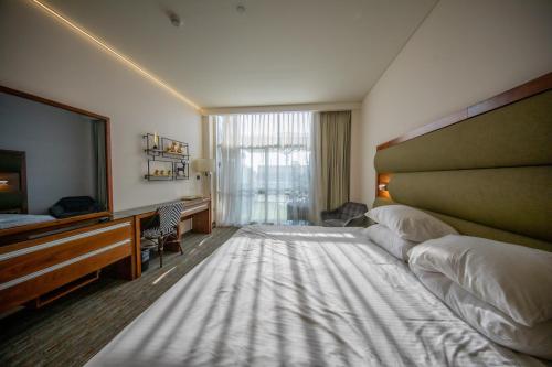 a hotel room with a large bed and a television at Garden Hotel Boutique & Events in Haifa