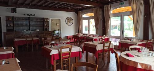 restauracja ze stołami i krzesłami oraz zegarem na ścianie w obiekcie L'Escale de Die w mieście Die