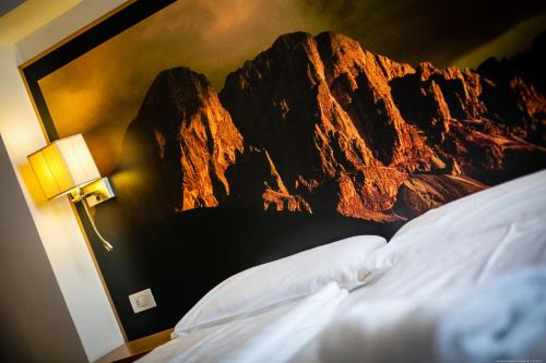 a bedroom with a mountain mural on the wall at Boutique Exclusive B&B in Trento