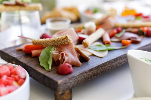 a cutting board with a variety of food on it at Melina Bay Boutique Hotel in Kassiopi