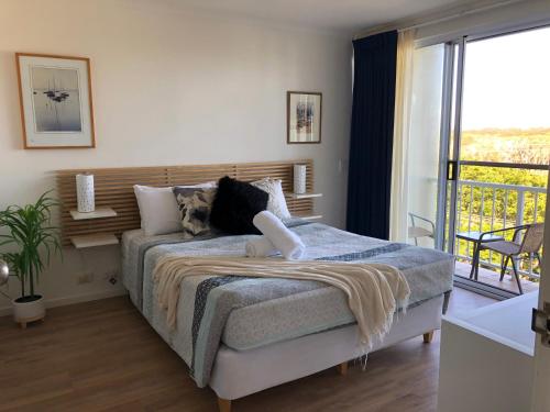 a bedroom with a bed and a balcony at Horizons At Peregian in Peregian Beach