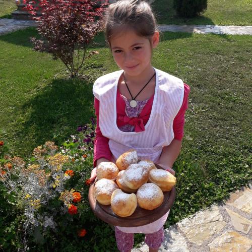 a young girl holding a basket of bread at Ethno House Bektesevic in Gusinje
