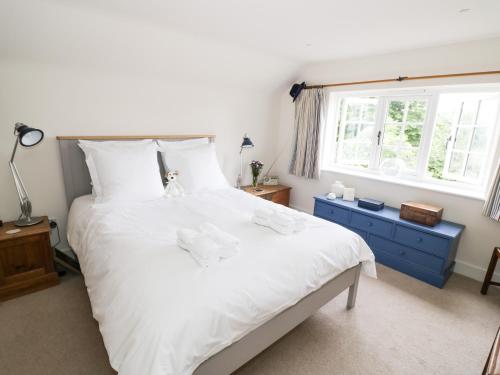 a bedroom with a large white bed and a window at Prospect Cottage in Malvern Wells