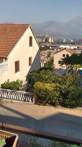 een groot wit huis met een straat ervoor bij Apartman Ipak Se Okrece in Trebinje