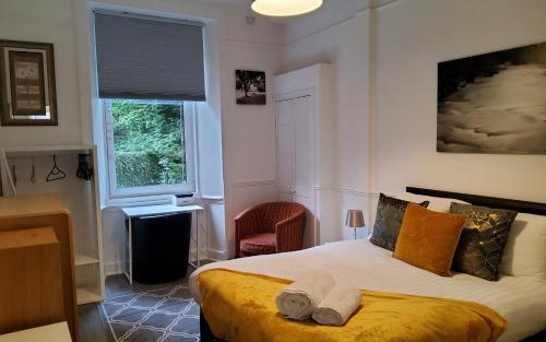 エディンバラにあるLeith Spectacular Apartment By Sensational Stay Short Lets & Serviced Accommodation With 6 Separate Beds & 2 Bathsのベッドルーム1室(ベッド1台、椅子、窓付)