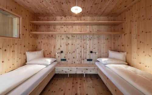 two beds in a sauna with wooden walls at Füchslhof in Marlengo