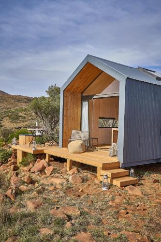 a small house with a table and a bench at Mount Camdeboo Private Game Reserve by NEWMARK in Graaff-Reinet