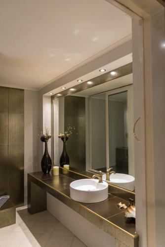 a bathroom with two sinks and a large mirror at Ruby Rooms Kifisia in Athens