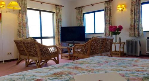 1 dormitorio con 1 cama, 2 sillas y TV en Villa Chanteria Carvoeiro fabulous 7 bedroom 7 bathroom villa with AC short walk to the beach, en Carvoeiro