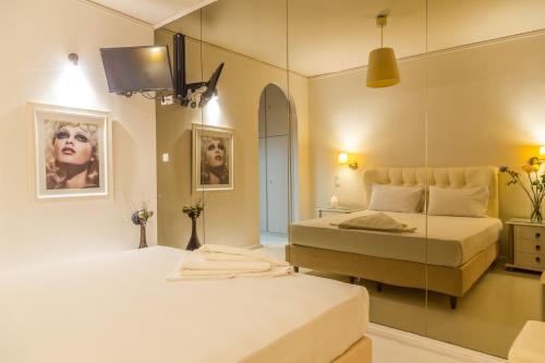 a bedroom with two beds and a mirror at Ruby Rooms Kifisia in Athens