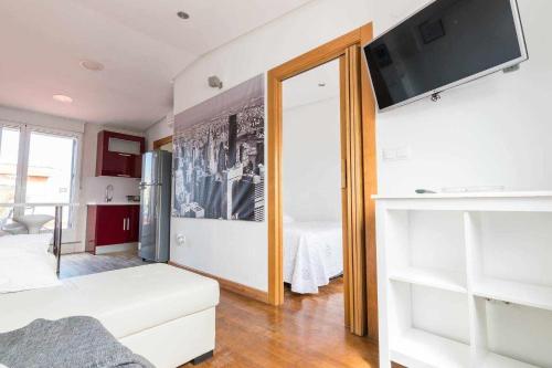a living room with a white couch and a flat screen tv at Apartamento Céntrico LA CATEDRAL in Murcia