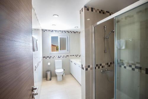 a bathroom with a toilet and a glass shower at Villa Dafnis Platina - Lovely 4 Bedroom Protaras Villa with Private Pool - Close to the Beach in Protaras