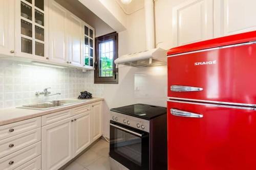 a kitchen with a red refrigerator and a sink at Mansion of 120 m2, with high ceilings and big yard in Evangelístria