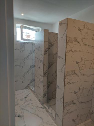 a bathroom with marble walls and a window at Laguna ubytovanie 2 A in Trenčín