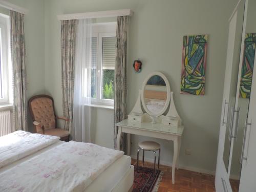 Schlafzimmer mit einem Bett, einem Schminktisch und einem Spiegel in der Unterkunft Appartement " Am Fasangarten " in Wien