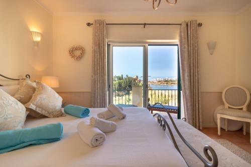 ein Schlafzimmer mit einem großen Bett und einem großen Fenster in der Unterkunft Luxury Townhouse n10 - Front-line Sea views in Ferragudo
