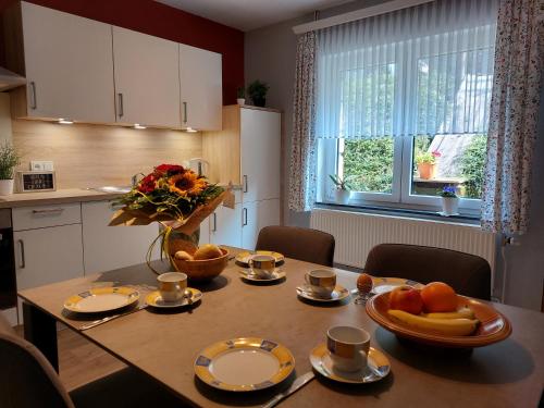 a kitchen with a table with a bowl of fruit on it at Ferienwohnung Setzer Mühle in Saint-Vith