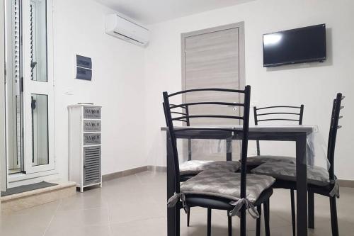 a room with two chairs and a television on a wall at LA PERLA DEL BAROCCO - NOTO in Noto
