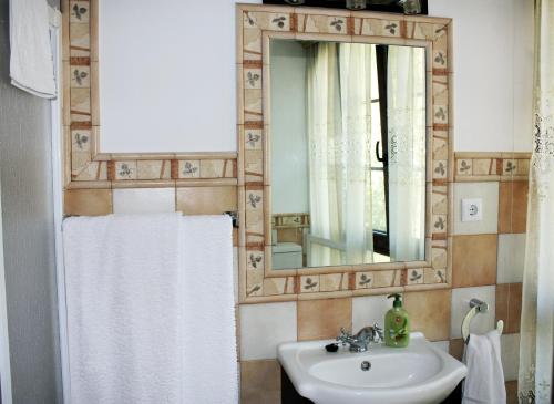 y baño con lavabo y espejo. en Hospedaje Angelica, en Santillana del Mar