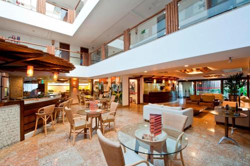 a lobby of a hotel with tables and chairs at Pontalmar Praia Hotel in Natal