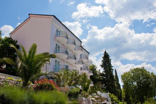 un edificio blanco con balcones en un lateral en Hotel Vali Dramalj, en Crikvenica