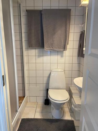 a bathroom with a toilet and a sink and towels at Pia's Apartment in Gothenburg