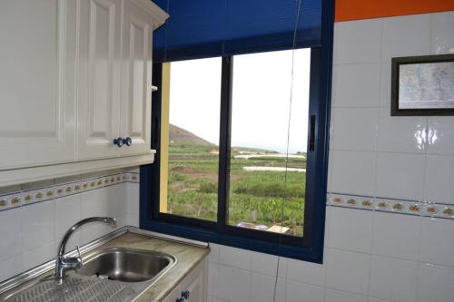 une cuisine avec un évier et une fenêtre dans l'établissement Bonito y amplio piso en Los LLanos de Aridane, à Los Llanos de Aridane