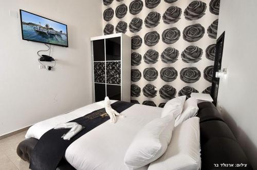 a bedroom with a bed and a wall of cupcakes at אחוזת שקד in Mishmār Hāyardin