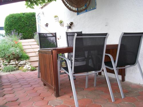 two chairs and a table with a television on a patio at Das Steghaus in Gräfenberg